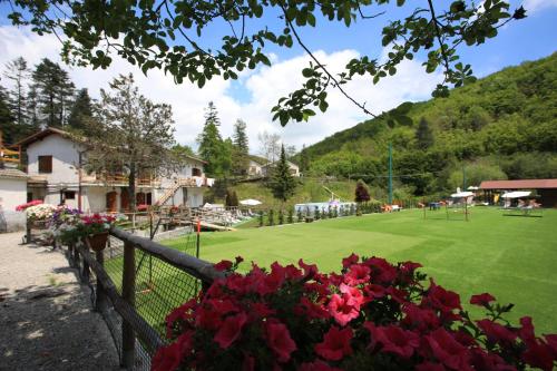 a green field with flowers and a fence at Green Riviera Case Vacanza in Borzonasca