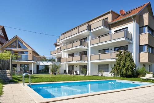 un edificio de apartamentos con piscina frente a él en Landhaus Hoher, en Oberteuringen