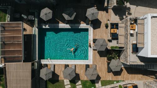 a person swimming in a swimming pool at Seascape Luxury Residences in Agia Pelagia