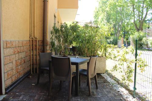 stół i krzesła na patio z roślinami w obiekcie Residence Royal House w mieście Riva del Garda