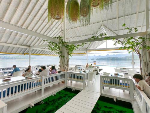 a restaurant with a view of the ocean at 500 Rai Floating Resort in Ratchaprapha