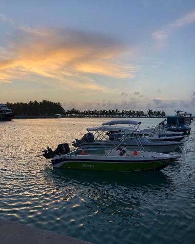 three boats are docked in the water at sunset at Veli Beach Inn in Mathiveri