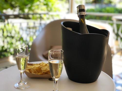 a bottle of champagne in a black container on a table with two glasses at Hotel Villa Serena in Castrocaro Terme