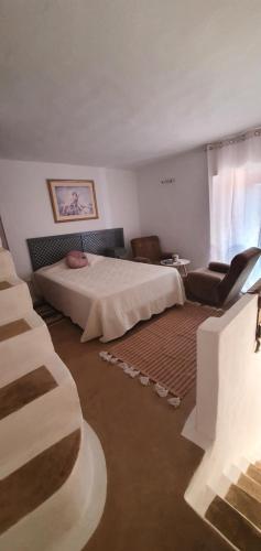 um quarto com uma cama e uma cadeira em Villa Rosa Boutique em Almancil