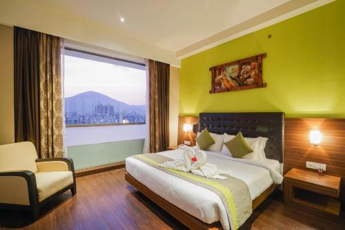 a hotel room with a bed and a large window at The Byke Suraj Plaza Pure Veg, Thane in Thane