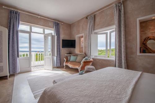 a bedroom with a bed and a large window at Charlotte House in Stilbaai