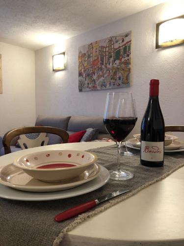 a table with a bottle of wine and a glass at Maison Francey in Pré-Saint-Didier