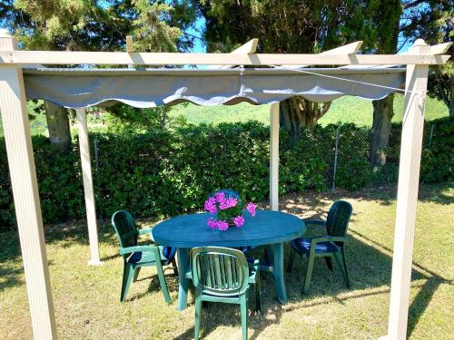 a blue table and chairs under an umbrella at Agriturismo L'Antica Quercia in Pomarance