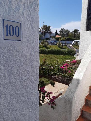 a sign on the side of a building with flowers at Pedras d'el Rei - Casa Mira in Tavira
