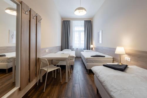 a room with four beds and a table and chairs at East Station DeLuxe in Budapest
