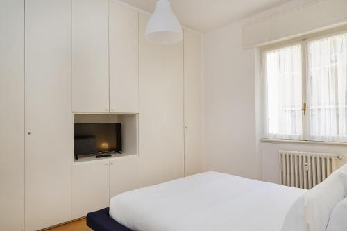 una camera bianca con letto e TV di Una Casa al Mare nel cuore di Rapallo by Wonderful Italy a Rapallo