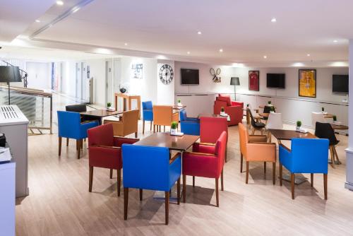 a restaurant with colorful chairs and tables in a room at Hotel Madrid Alameda Aeropuerto, Affiliated by Meliá in Madrid