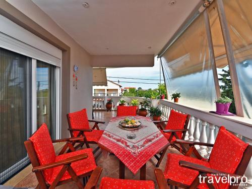 a patio with a table and chairs on a balcony at Villa Vangelis in Nea Plagia