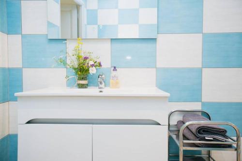 La salle de bains est pourvue d'un lavabo et d'une chaise fleurie. dans l'établissement Regina's Banyuls - comfortable and next to the beach, à Banyuls-sur-Mer