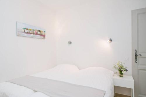 une chambre blanche avec un lit et une table dans l'établissement Regina's Banyuls - comfortable and next to the beach, à Banyuls-sur-Mer