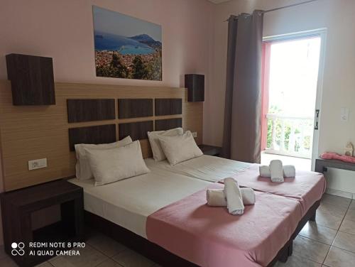 a bedroom with a large bed with two pillows on it at No Name Apartments in Laganas