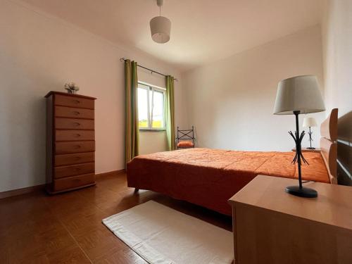 リバマルにあるVilla Patrocinioのベッドとドレッサーと窓のある寝室