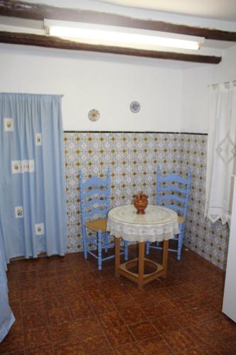 a table and chairs in a room with blue curtains at EL CASTELLET in Traiguera