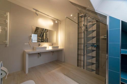 Un baño con lavabo y ducha de cristal. en Domki i Apartamenty Nad Wodospadem, en Szczawnica
