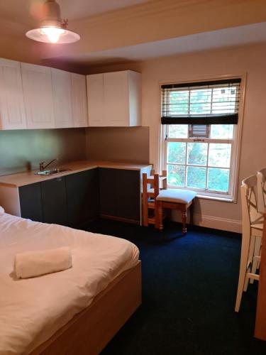 a bedroom with a bed and a sink and a kitchen at Cathedral Hotels Norwich in Norwich