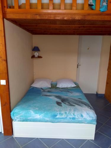 - une chambre avec un lit doté d'un couvre-lit avec un dauphin dans l'établissement Studio à St Pierre en Port, à Saint-Pierre-en-Port