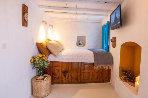 a bedroom with a bed and a vase of flowers at Nacros Villa Olympos Karpathou in Olympos
