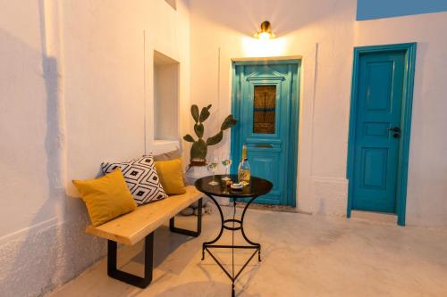 a room with a blue door and a bench and a table at Nacros Villa Olympos Karpathou in Olympos