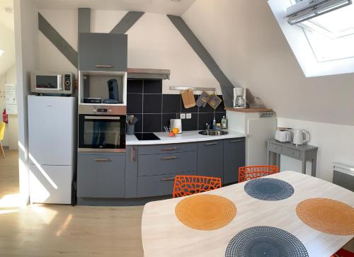 une cuisine avec une table et un réfrigérateur blanc dans l'établissement SUPERLOGIS - Sous Les Toits - T2- 3étoiles - BLOIS-HYPERCENTRE 1 chambre 4 personnes, à Blois