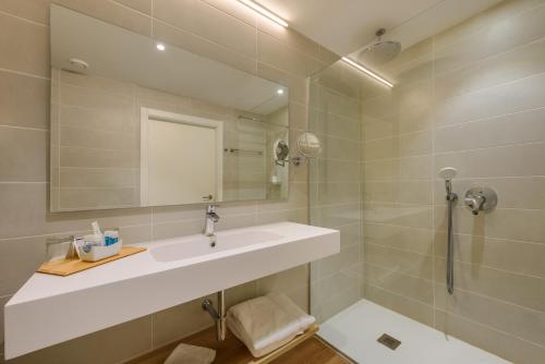 a bathroom with a sink, mirror and bath tub at Son Corb Boutique Hotel in Cala Bona