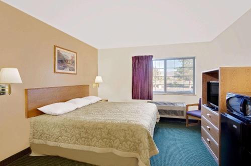 um quarto de hotel com uma cama e uma televisão em Super 8 by Wyndham Battle Mountain em Battle Mountain