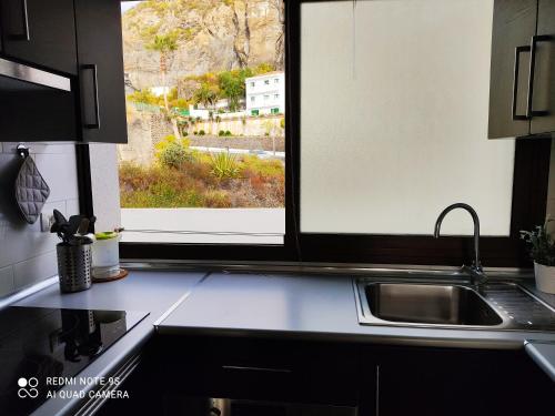 a kitchen counter with a sink and a window at Sea loft with a huge bed in Icod de los Vinos