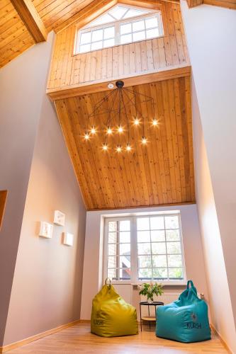 a room with a wooden ceiling with a chandelier at Kurshi Hotel & Spa in Jūrmala