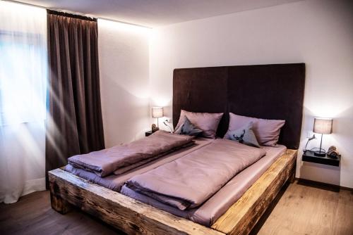 1 dormitorio con 1 cama grande y cabecero de madera en Apartment Schifta, en Chienes