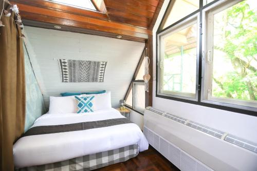 a small bedroom with two beds and a window at Evergreen Pakchong Home in Pak Chong