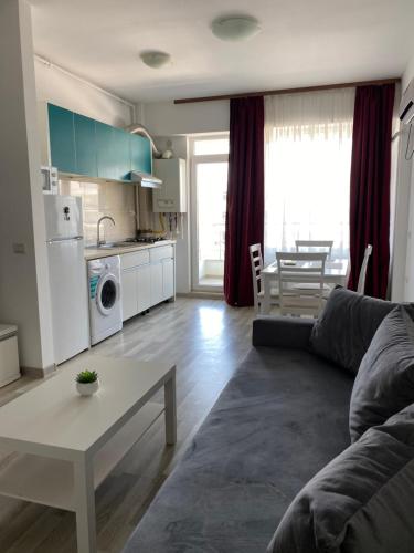 ein Wohnzimmer mit einem Sofa und einem Tisch in der Unterkunft Apartament Bebe Summerland in Mamaia