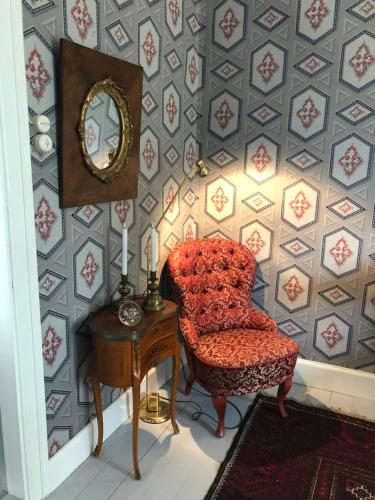 a room with a chair and a table with a mirror at Träslottets B&B in Arbrå