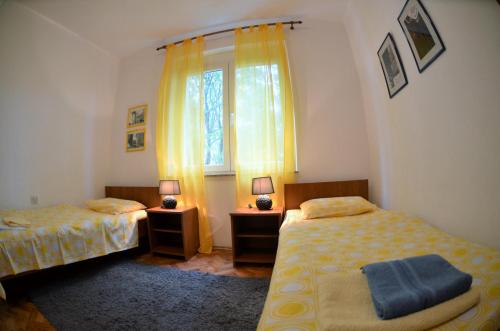 a bedroom with two beds and a window at Apartment Zic in Krk