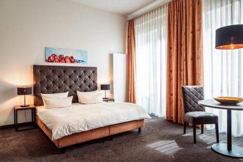 a bedroom with a bed and a table and a chair at Aparthotel Neumarkt in Dresden