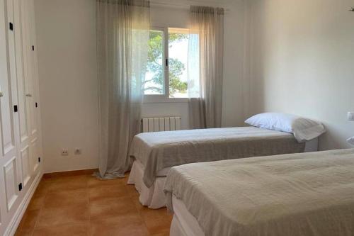 sypialnia z dwoma łóżkami i oknem w obiekcie Casa Mar Blau - mediterranean house w mieście Puigderrós
