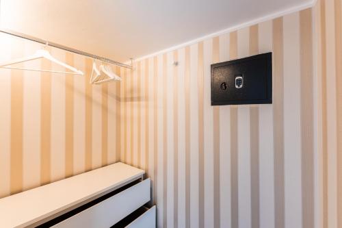 a room with striped walls and a tv on the wall at BeB Palazzo Mancini in Minori