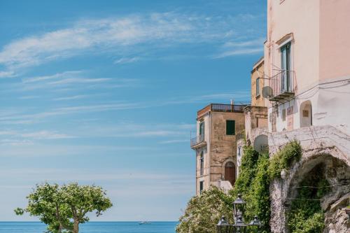 an old building on a cliff next to the ocean at BeB Palazzo Mancini in Minori