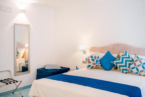 a bedroom with a bed with blue and white pillows at BeB Palazzo Mancini in Minori