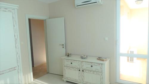 a white bathroom with a sink and a mirror at Captain's Island Deluxe in Chernomorets