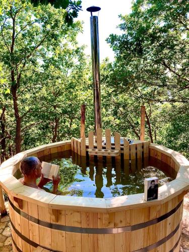 a wooden pool of water with a person in it at HAPPY GLAMPING MADONIE in Polizzi Generosa