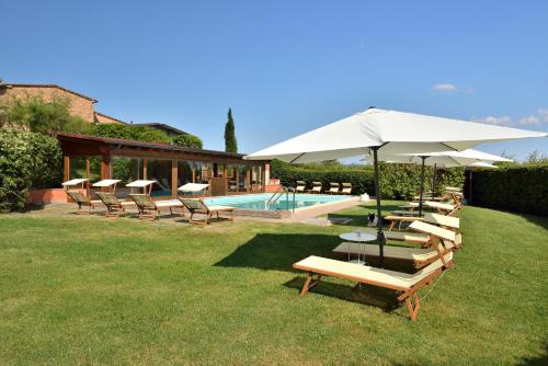 a group of chairs and an umbrella next to a pool at Porsenna Resort in Villastrada