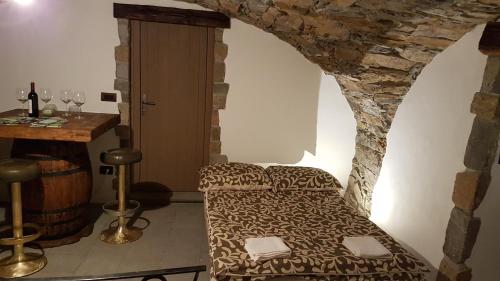 a room with a bed and a table with wine glasses at Wine cellar room in Vipava