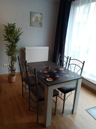 een eettafel met zwarte stoelen en een tafel bij Chez isa in Saint-Hubert