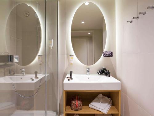 a bathroom with a sink and a mirror at Aparthotel Adagio access München City Olympiapark in Munich