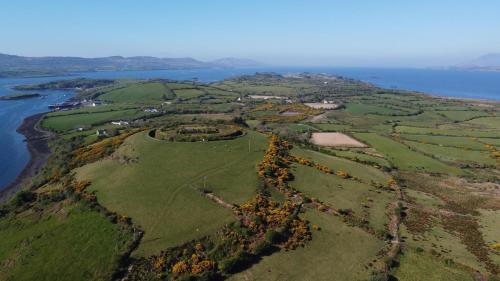 an aerial view of a green field next to the water at Whiddy School House Accommodation in Ladyʼs Odell