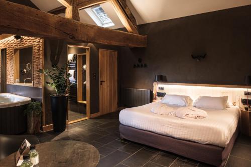 1 dormitorio con 1 cama grande y lavamanos en Le Domaine des Prés Verts Suites & Chambres avec Jacuzzi Privatif à Châteauneuf, en Châteauneuf